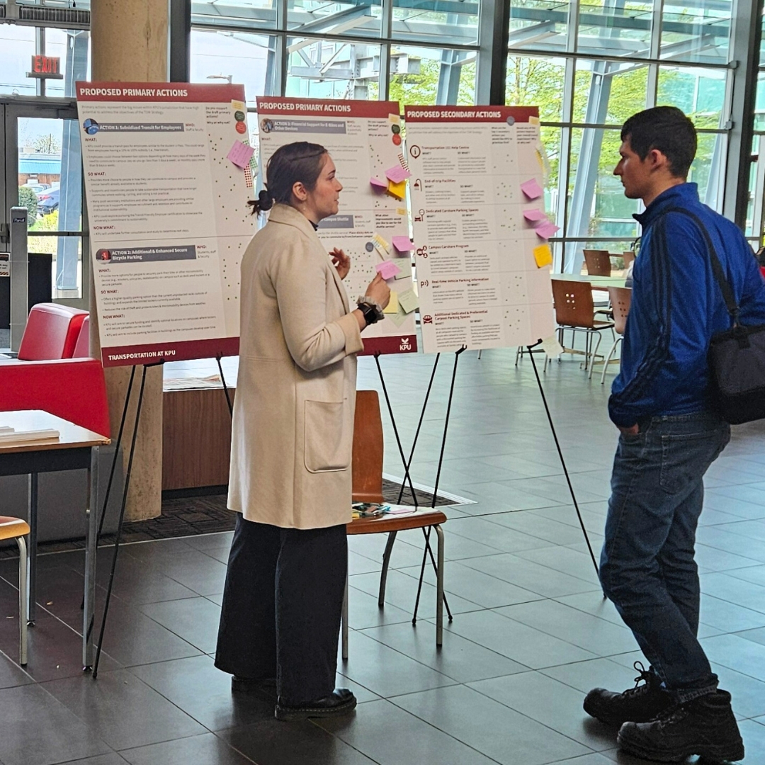 two people standing in front of three boards on easels 